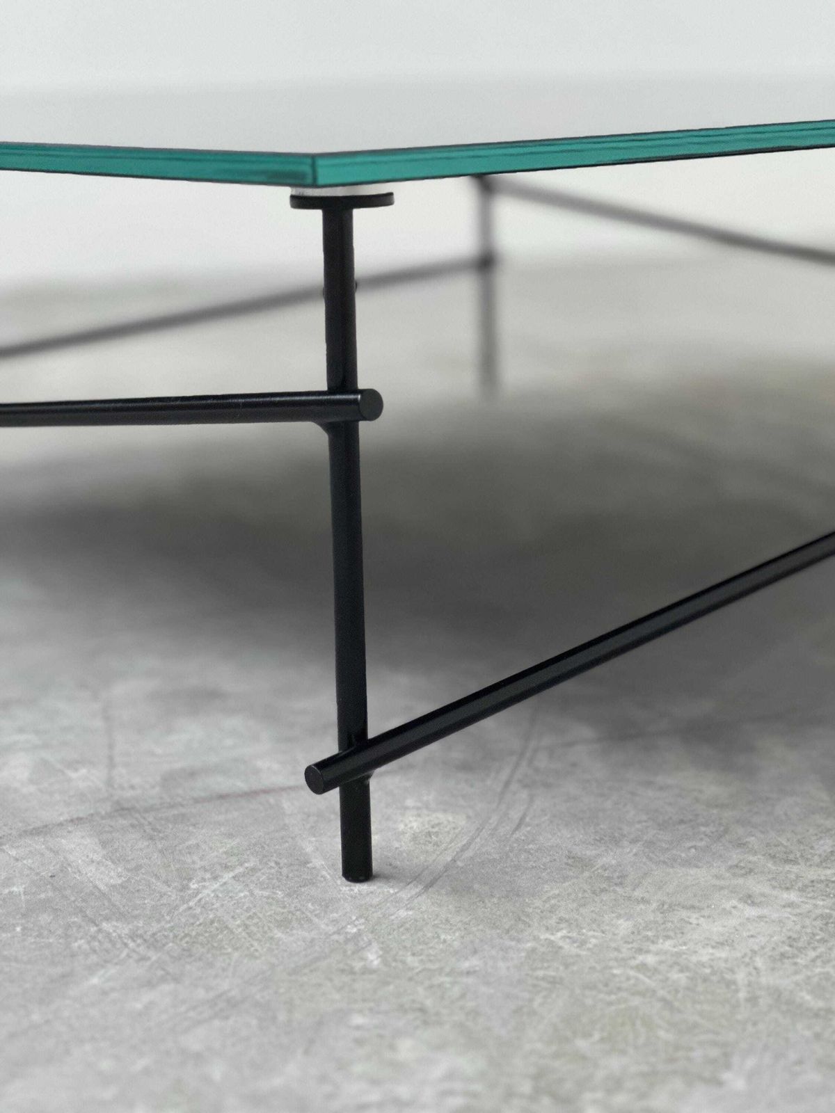 Minimalistische salontafel van zwart glas met industrieel metalen onderstel photo for sale
