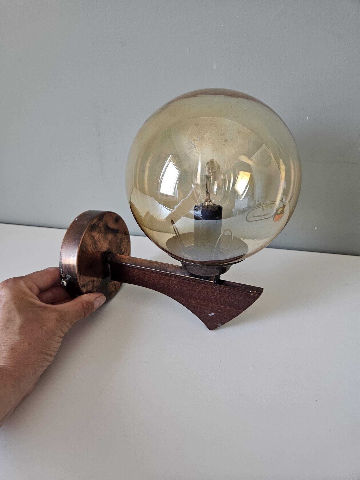 Vintage wandlamp van koper en hout met amberkleurige glazen bol – Mid-Century Modern photo vintage