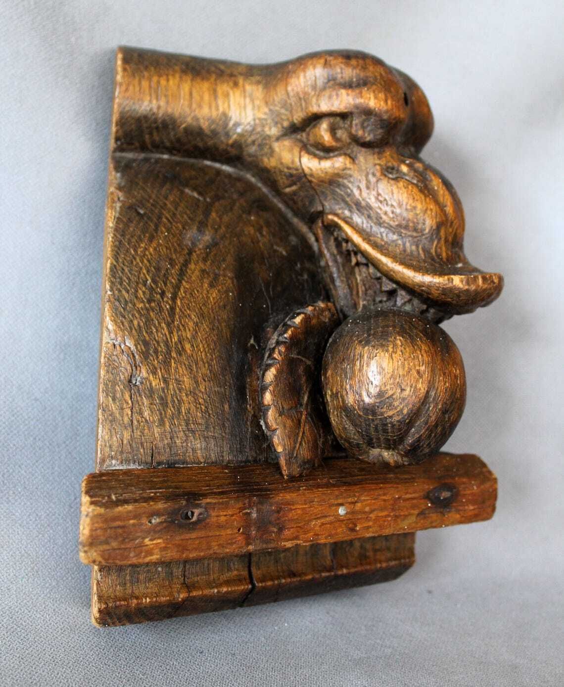 Groot antiek houten ornament in de vorm van een slangenkop met tanden die een appel of granaatappel eet, driedimensionaal, handgesneden, gotische architectuur photo 130.0