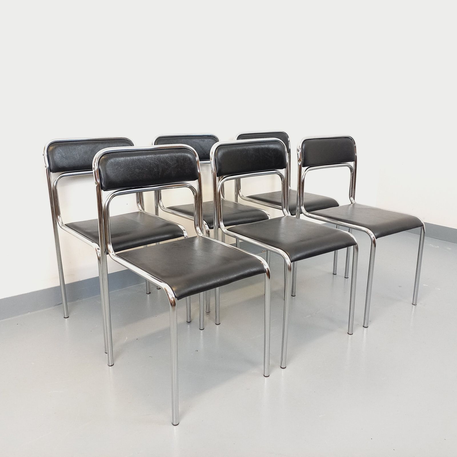 6 Italiaanse stoelen van verchroomd metaal en zwart kunstleer