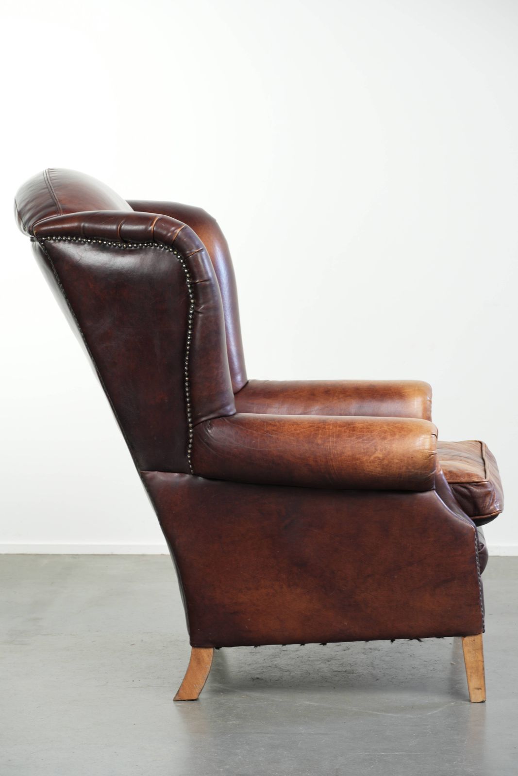 Comfortable English Style Cowhide Wing Armchair With A Beautiful Warm Color Scheme And A Characterful Appearance. photo for sale