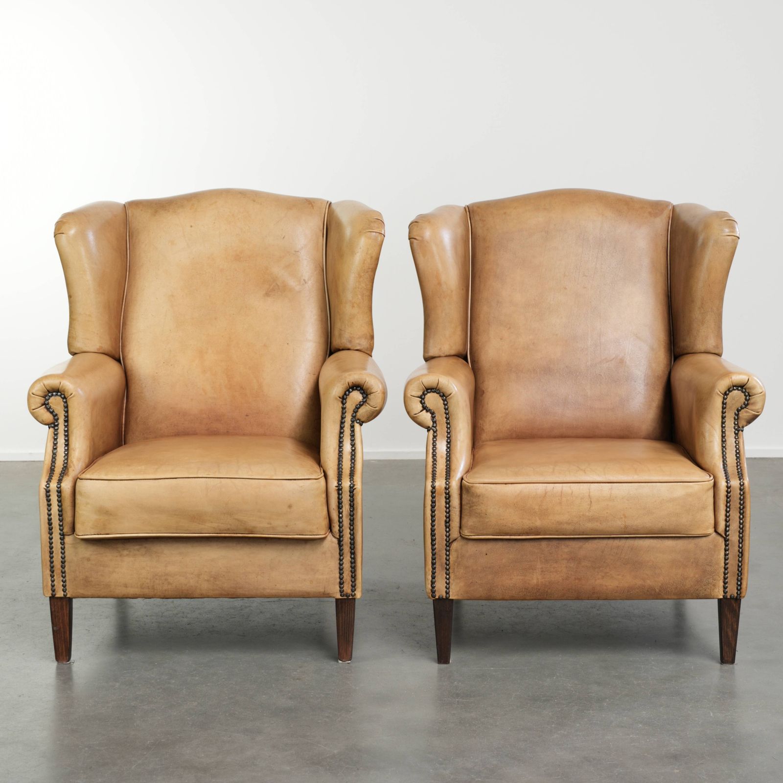 Set Of Two Beautiful Light Cowhide Wing Armchairs With A Timeless English Look And Good Seating Comfort