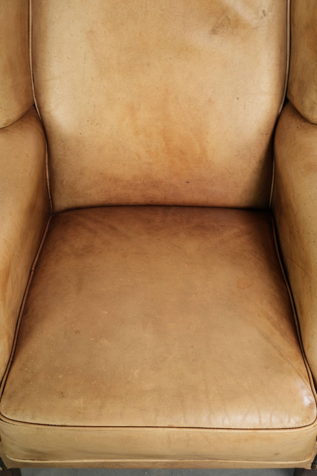 Lichte koeienhuid fauteuil met vleugelleuningen, een mooie tijdloze Engelse uitstraling en goed zitcomfort. photo vinterior