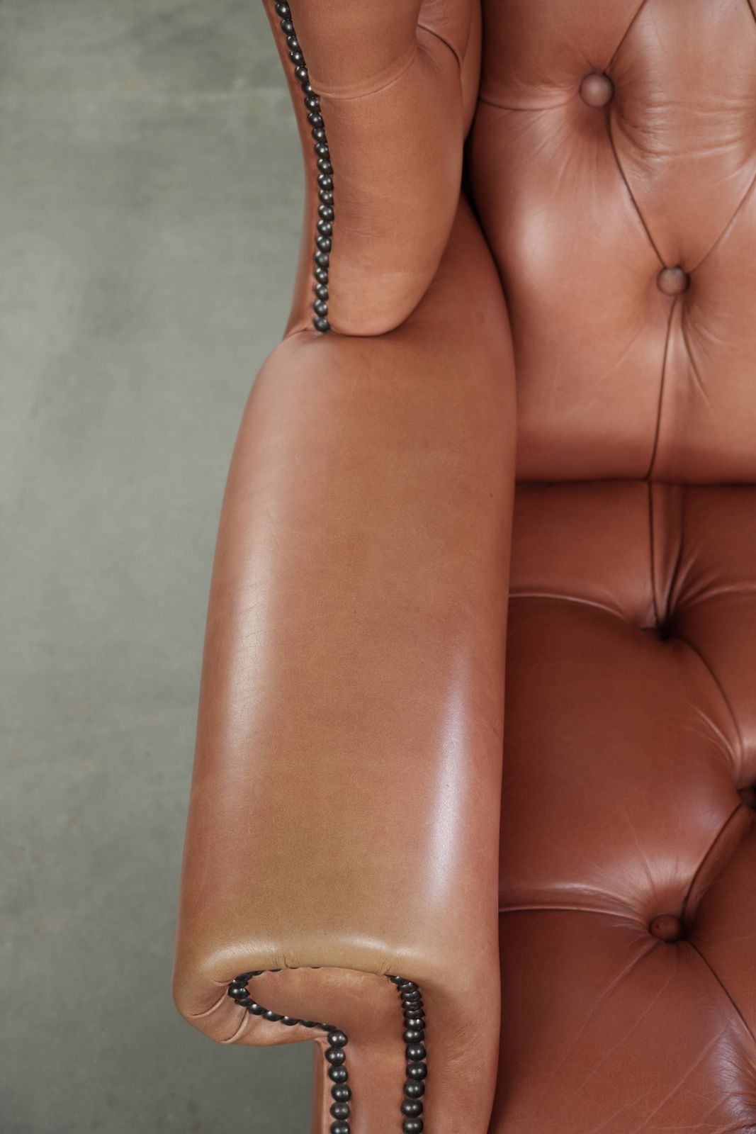 Klassieke Engelse Chesterfield-vleugelfauteuil met koeienhuid, knoopsluiting, mooie patina en fraaie kleuren. photo buy