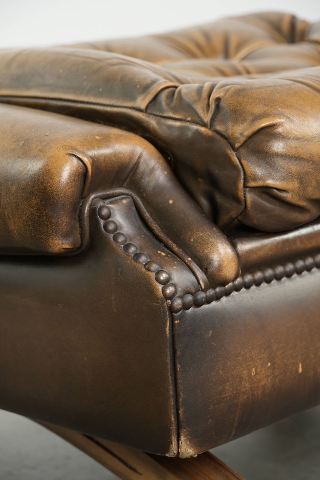 Unieke en elegante Engelse Chesterfield ottoman in koeienhuidleer op wieltjes, afgewerkt met decoratieve nagels. photo vintage