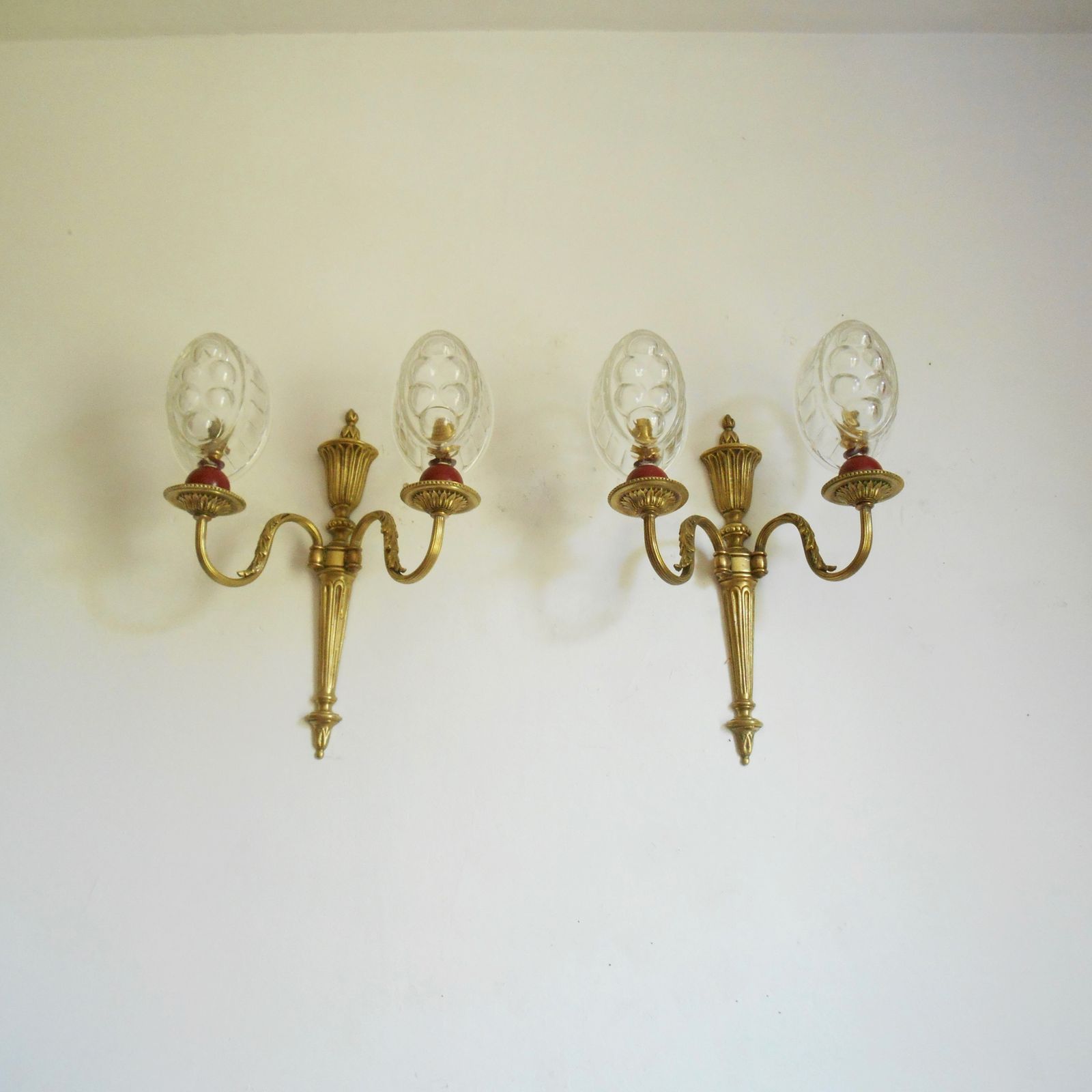 Paar Franse antieke wandlampen van massief messing met dubbele arm en glazen puddingvormschaduwen photo for sale