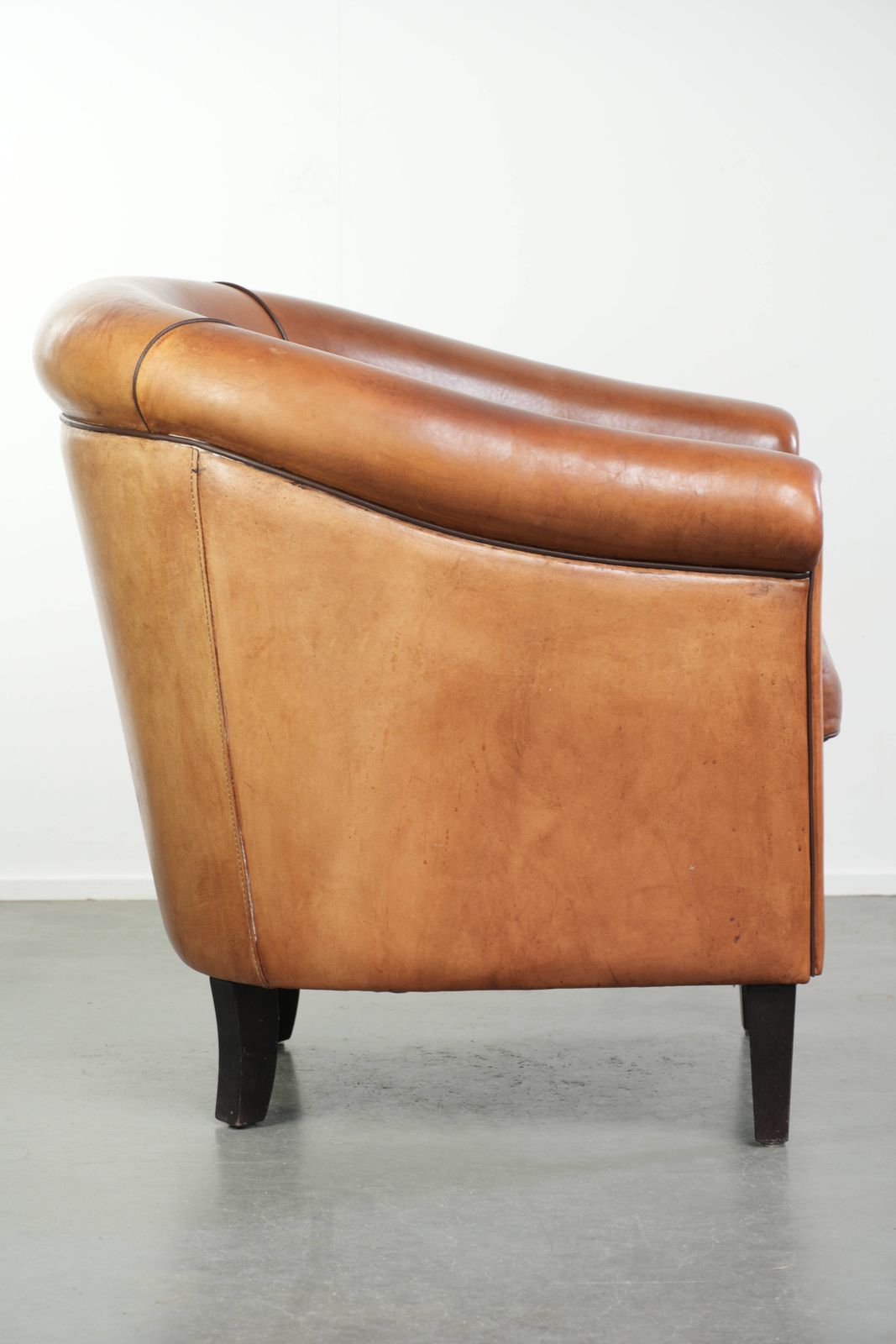 Vintage Schapenvacht Club Fauteuil Met Warm Kleurenschema En Afgewerkt Met Zwarte Paspel. photo for sale