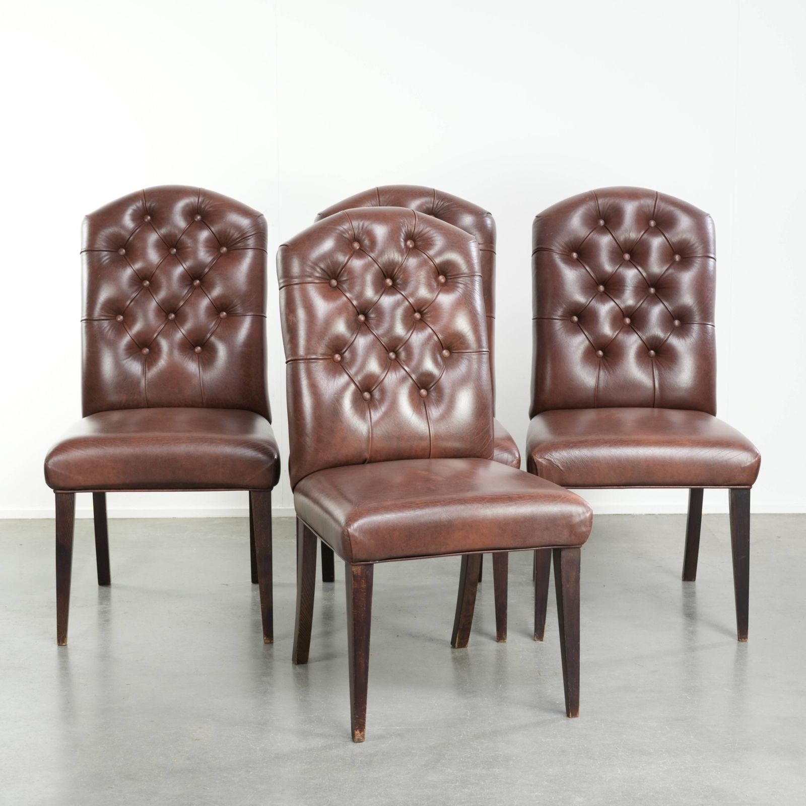 Mooie set van 4 vintage koehuid Chesterfield eetkamerstoelen in een mooie donkerbruine kleur.