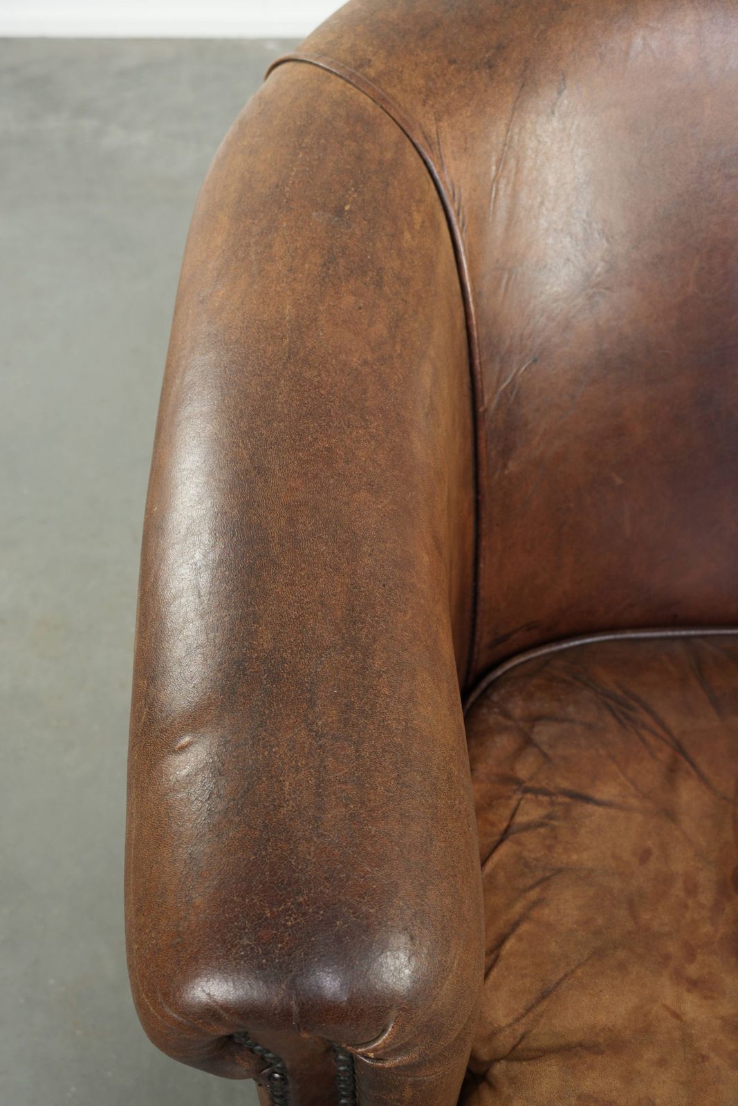 Stevige clubfauteuil in cognackleurig schapenleer met vintage uitstraling in Engelse stijl photo buy