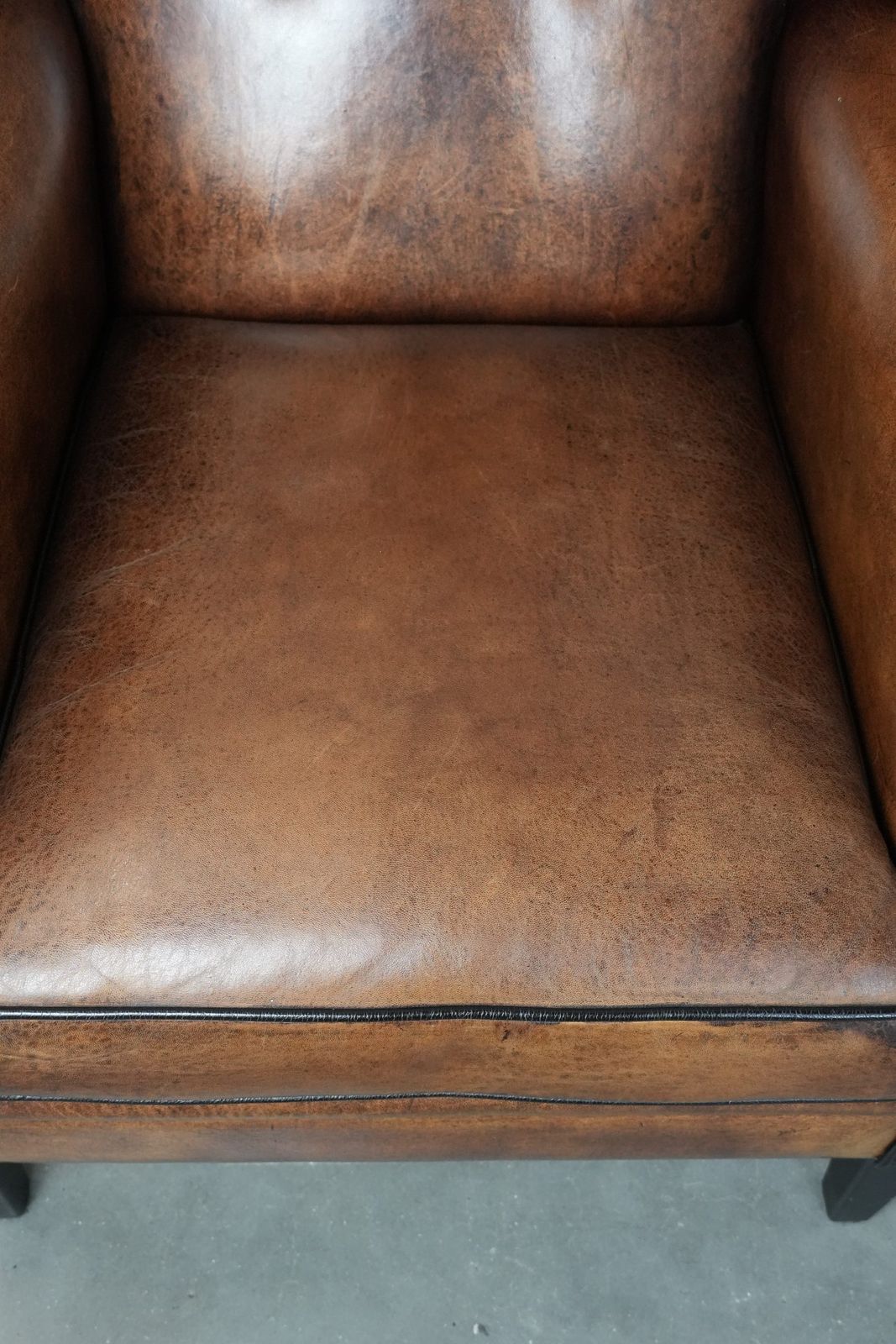 Timeless And Comfortable Sheepskin Wing Armchair With Beautiful Colors And A Finish With Decorative Nails And Black Piping. photo vinterior