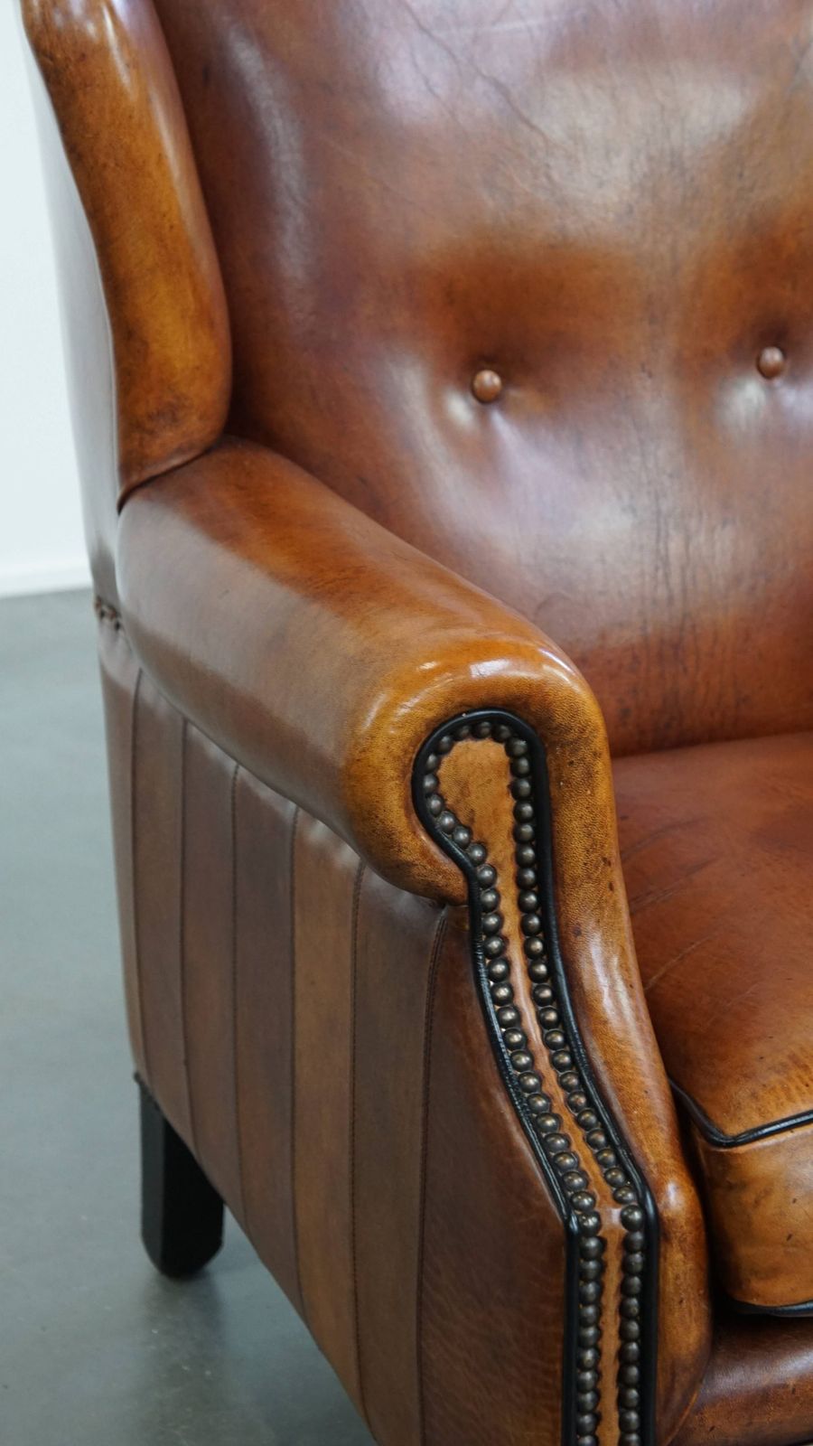 photo vinterior Comfortable Sheepskin Wing Armchair With A Beautiful Warm Color Scheme And A Finish With Stitching And Black Piping.