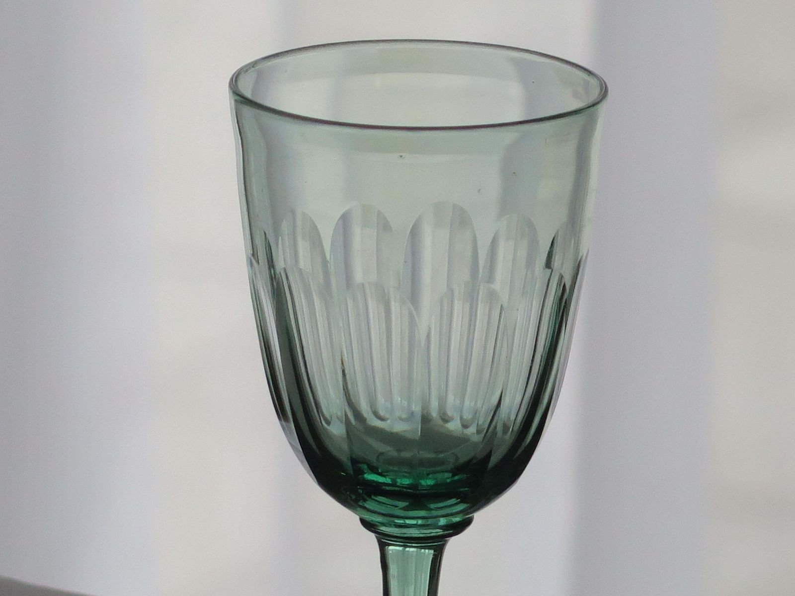 Met de hand geblazen lichtgroen wijnglas, geslepen panelen op de kelk, Engels, ca. 1840. photo for sale