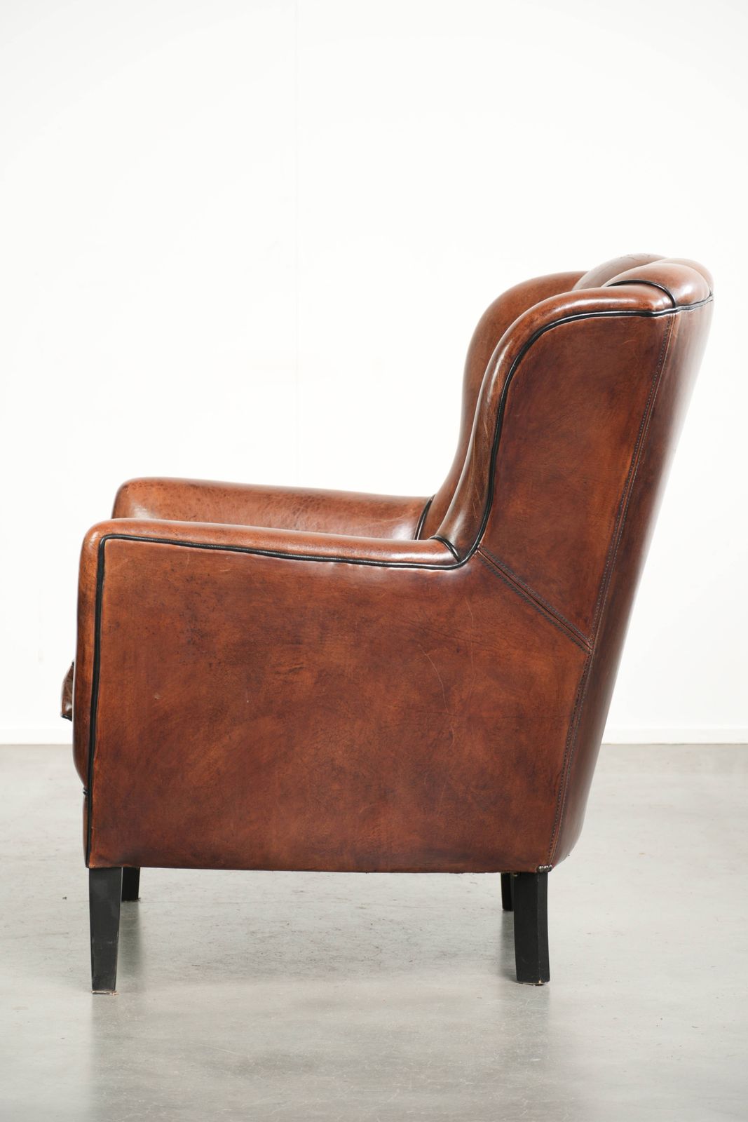 Comfortabele Schapenleren Fauteuil In Een Uniek Design Met Zwarte Biesafwerking photo 890.0