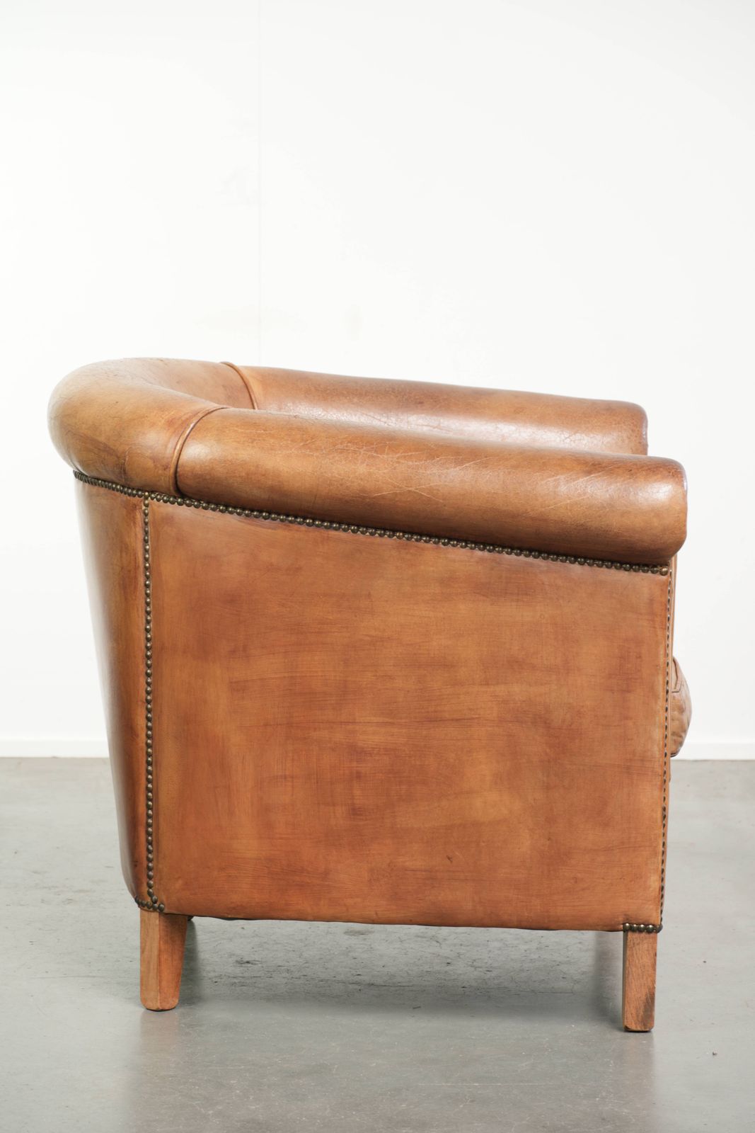 Stevige clubfauteuil in schapenleer, licht cognackleurig, afgewerkt met siernagels. photo for sale