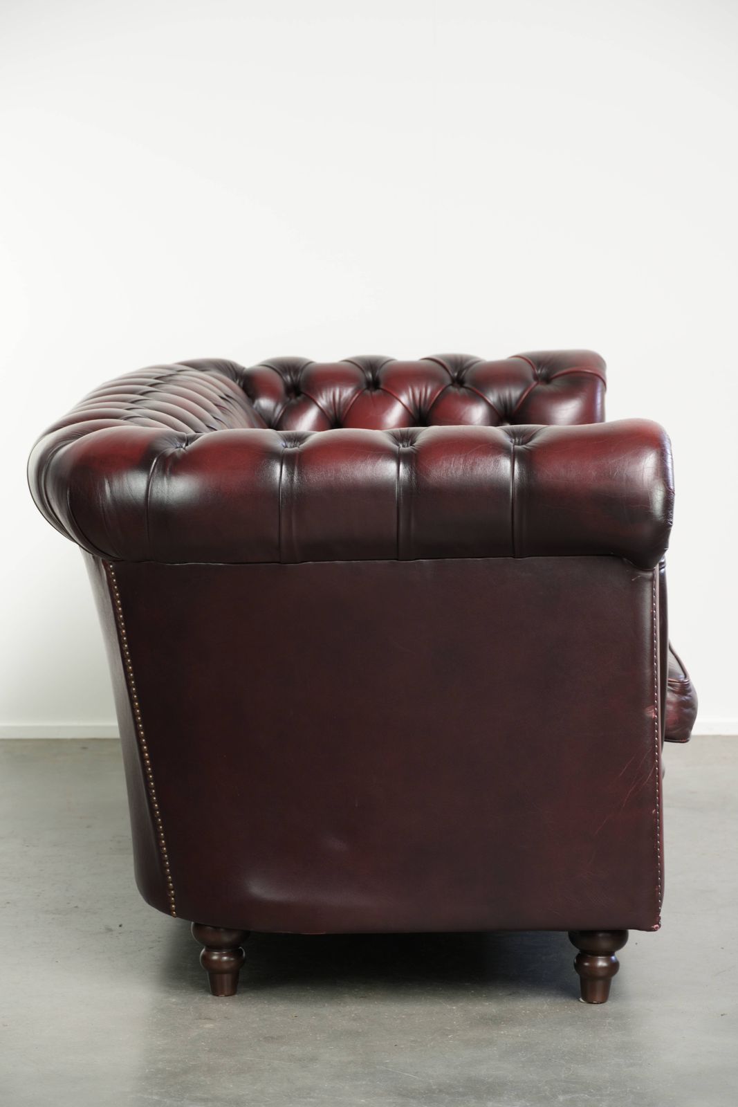 Tijdloze Chesterfield 2,5-zitsbank van koeienhuid in oxblood rood met mooie patina photo furniture