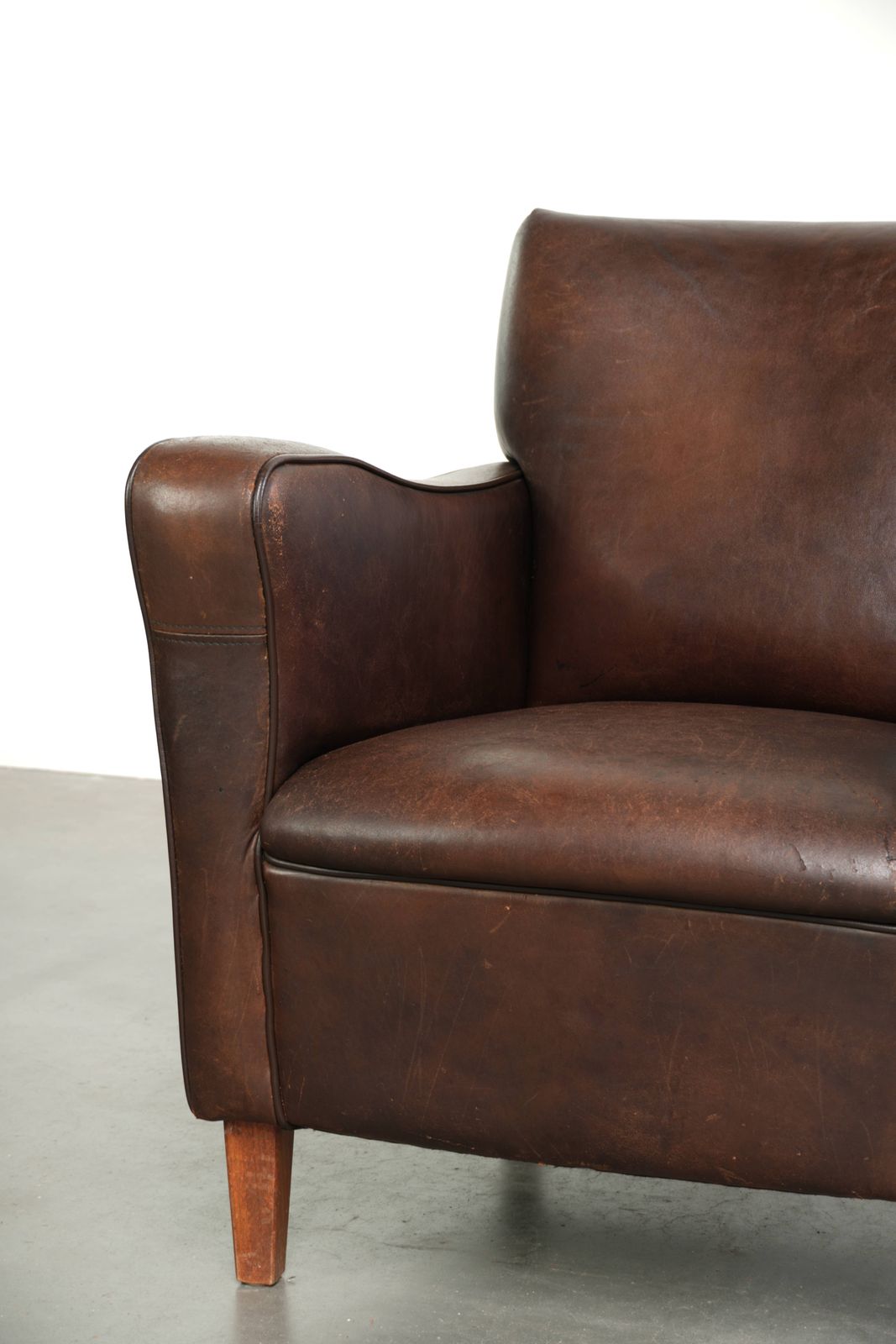 photo furniture Subtiele Donkere Vintage Schapenvacht Fauteuil Met Vast Zitkussen En Tijdloos Design