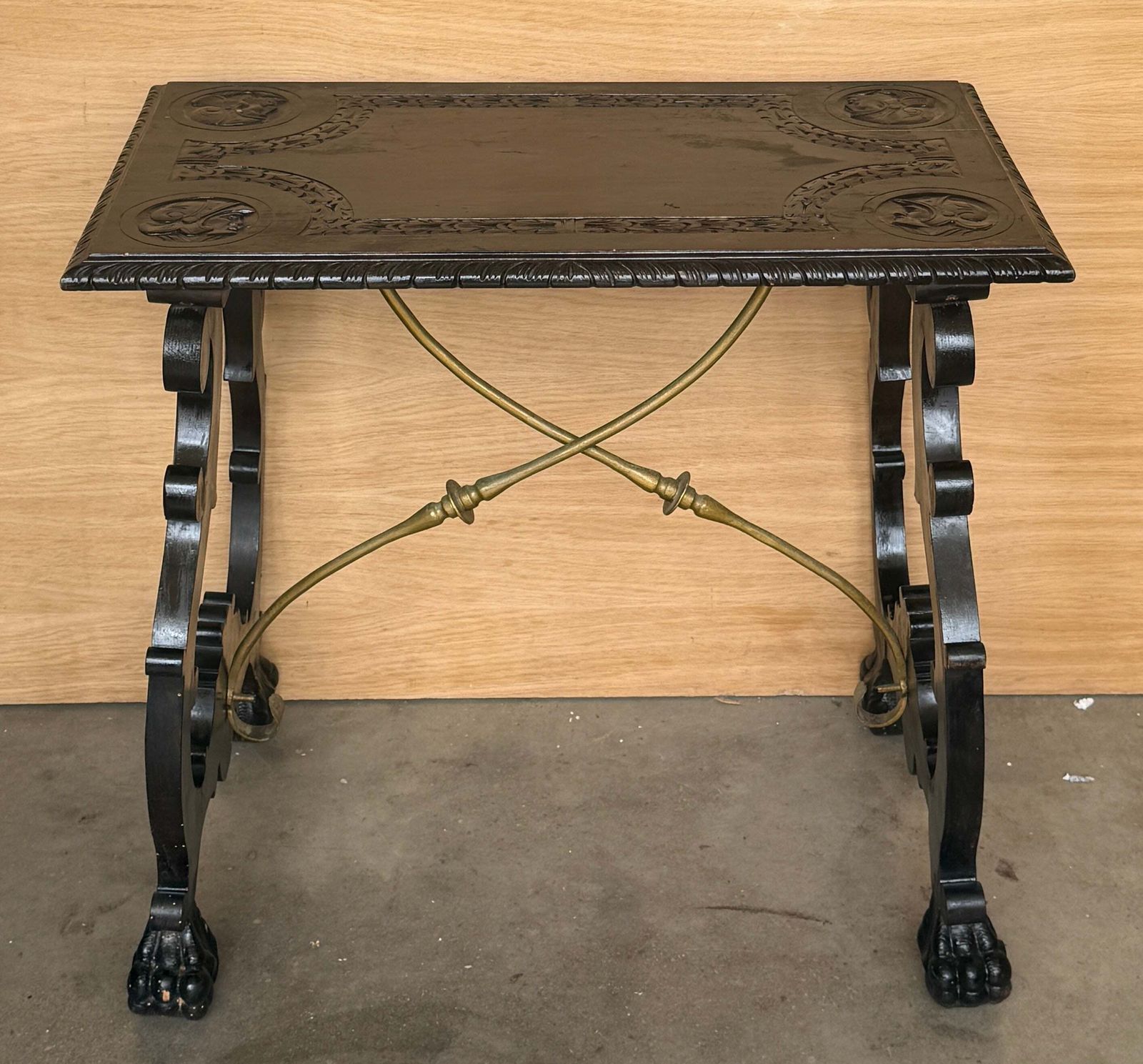 Table centrale d'époque en bois ébénisé sculpté, traverses en laiton et pieds en patte photo buy