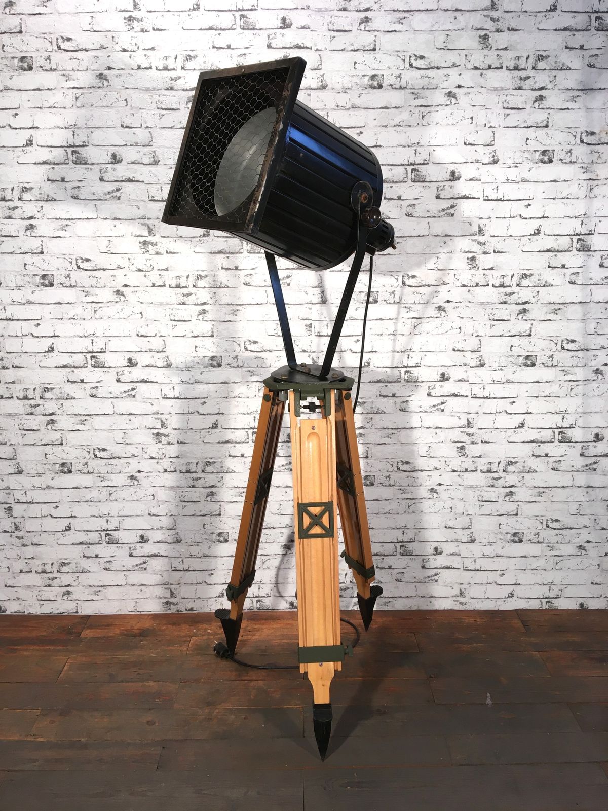 Black Vintage Industrial Spotlight On Wooden Tripod  photo furniture