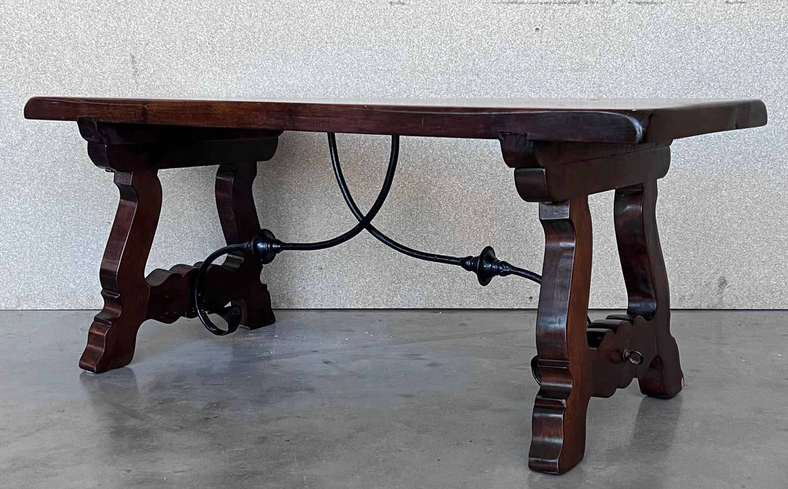 Table espagnole sculptée du XXe siècle avec traverses en fer photo buy