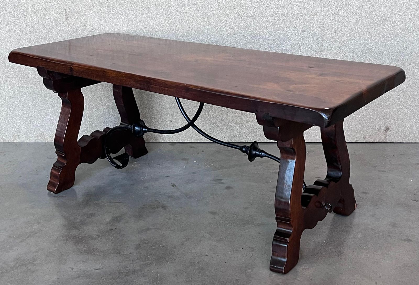Table espagnole sculptée du XXe siècle avec traverses en fer photo vintage